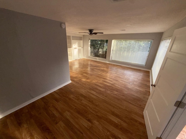 unfurnished room with wood-type flooring, a textured ceiling, and ceiling fan