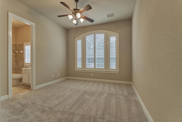 carpeted spare room featuring ceiling fan