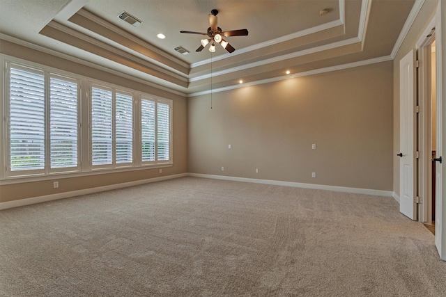 carpeted spare room featuring a raised ceiling, ceiling fan, and ornamental molding