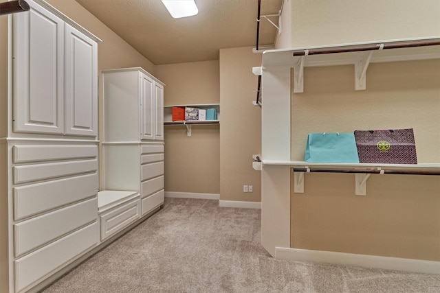 walk in closet featuring light carpet