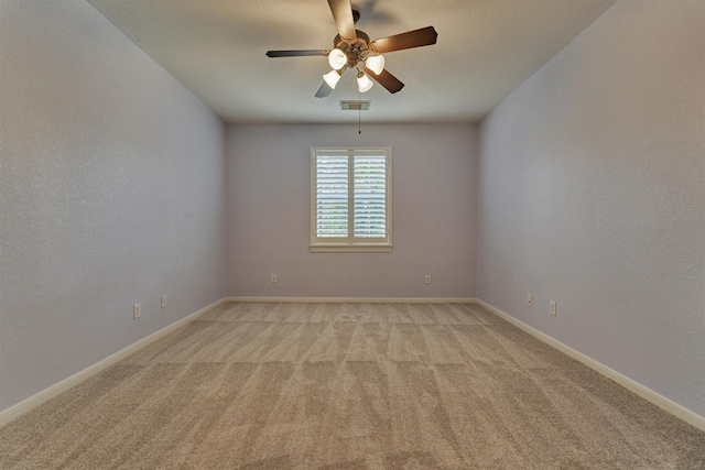 spare room with ceiling fan and light colored carpet