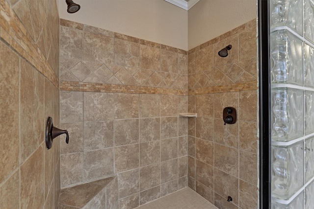 bathroom with crown molding and tiled shower