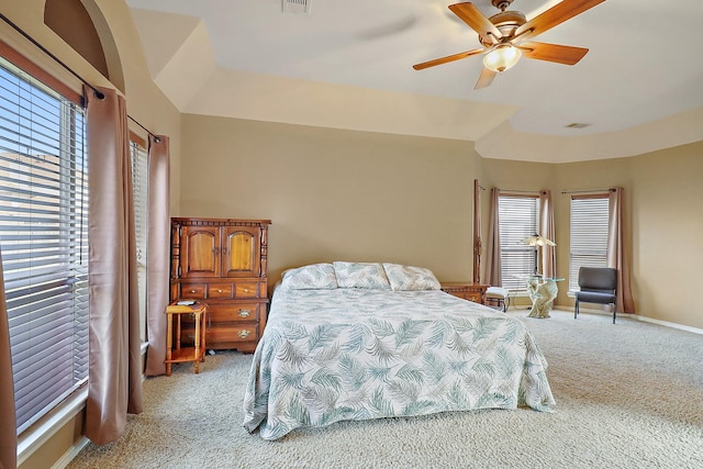 carpeted bedroom with multiple windows and ceiling fan