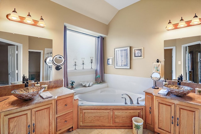 bathroom with tile patterned floors, a bathing tub, vanity, and lofted ceiling