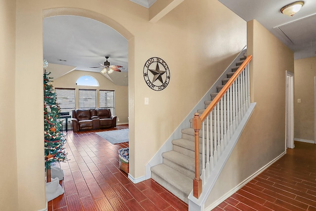 stairway featuring ceiling fan, hardwood / wood-style floors, and vaulted ceiling