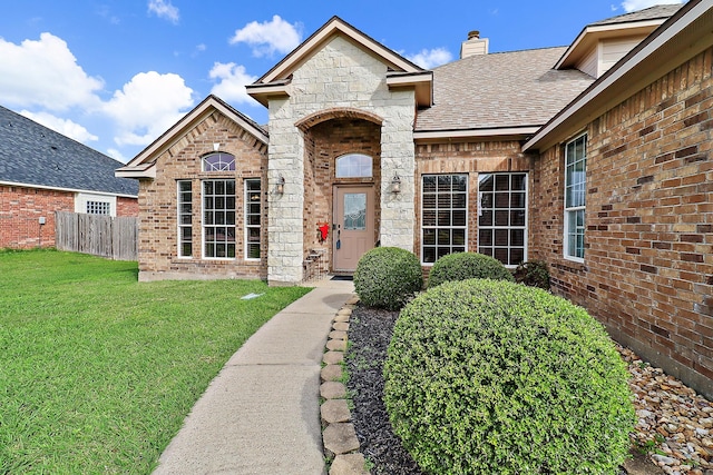 view of exterior entry with a yard