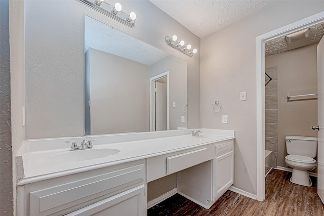 full bathroom with a textured ceiling, vanity, shower / washtub combination, hardwood / wood-style flooring, and toilet