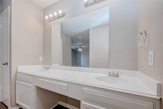 bathroom featuring vanity, ceiling fan, and a textured ceiling