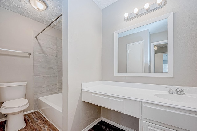 full bathroom featuring wood-type flooring, a textured ceiling, toilet, vanity, and shower / bathtub combination