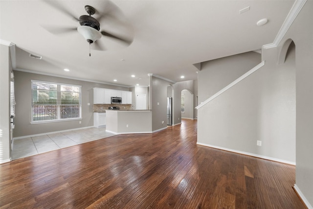 unfurnished living room featuring crown molding, ceiling fan, and light hardwood / wood-style floors