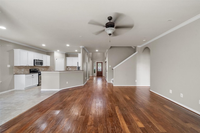 unfurnished living room with light hardwood / wood-style flooring, ceiling fan, and ornamental molding