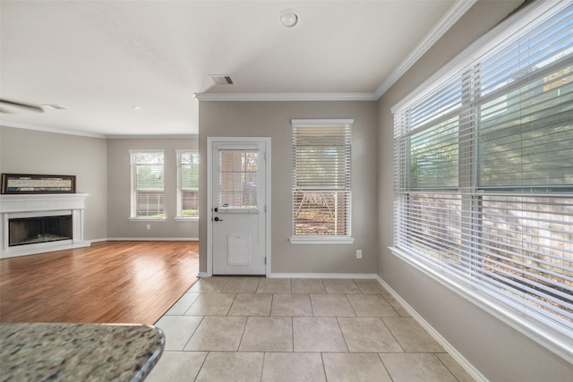 entryway with light hardwood / wood-style flooring and ornamental molding