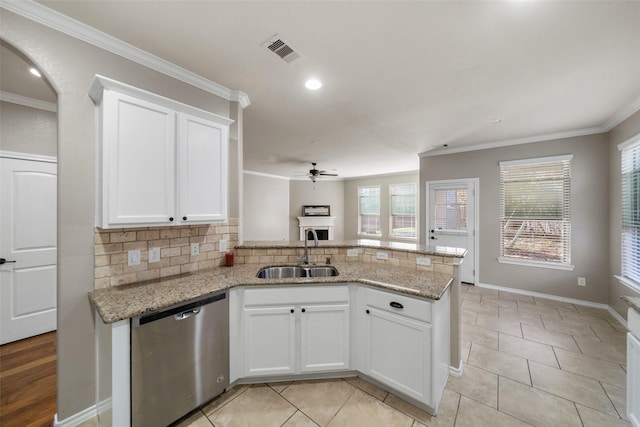 kitchen featuring light stone counters, white cabinetry, stainless steel dishwasher, and sink