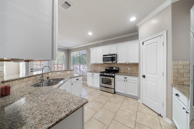 kitchen featuring white cabinets, crown molding, sink, light stone countertops, and stainless steel appliances