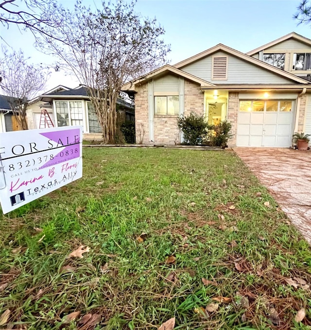 ranch-style home with a garage and a front lawn