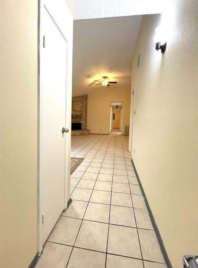 corridor featuring light tile patterned floors and vaulted ceiling