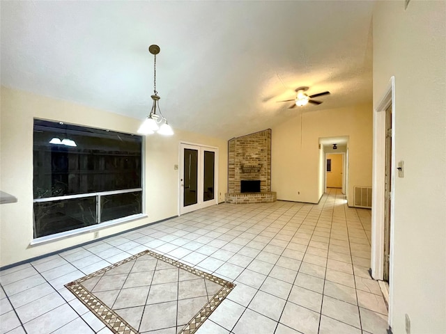 unfurnished living room with a brick fireplace, vaulted ceiling, ceiling fan, a textured ceiling, and light tile patterned flooring