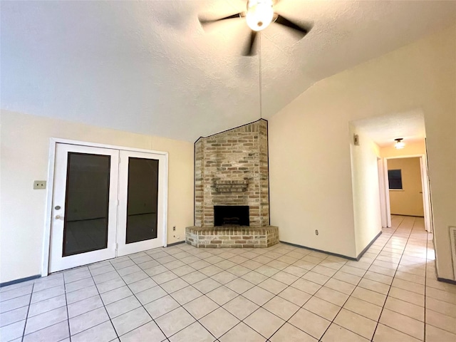 unfurnished living room featuring a textured ceiling, ceiling fan, a fireplace, lofted ceiling, and light tile patterned flooring