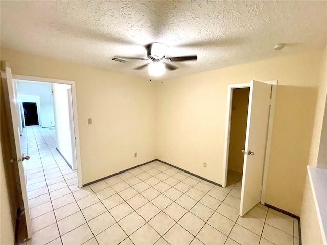 tiled spare room featuring ceiling fan and a textured ceiling