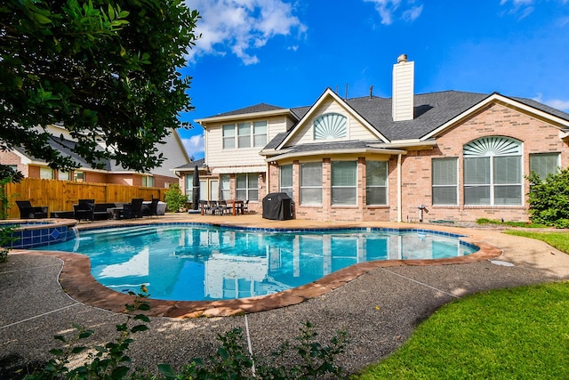 view of swimming pool with area for grilling, a patio area, and an in ground hot tub