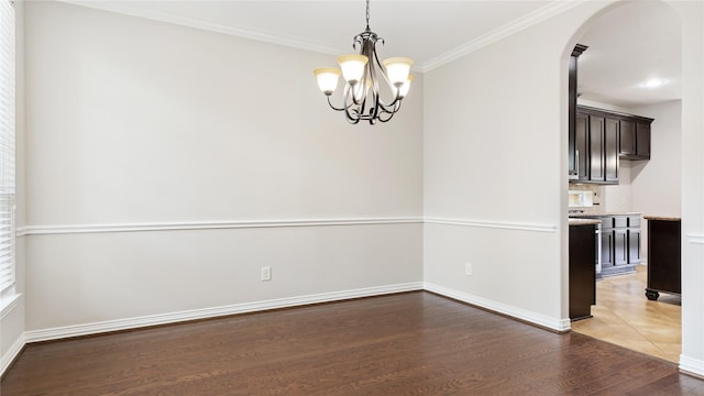 unfurnished dining area featuring a notable chandelier, ornamental molding, and dark wood-type flooring