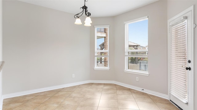 unfurnished dining area featuring light tile patterned floors and an inviting chandelier