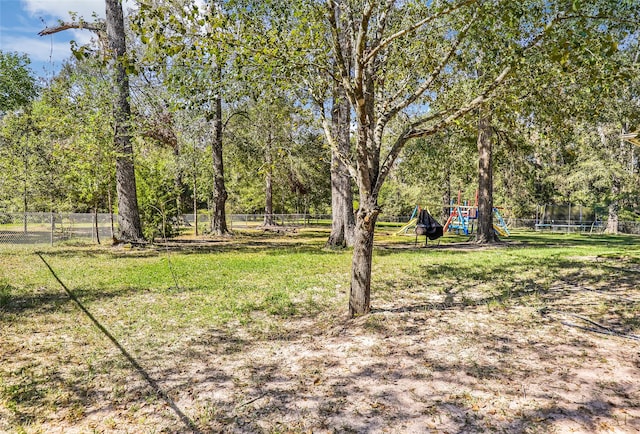 view of yard featuring a playground and a trampoline