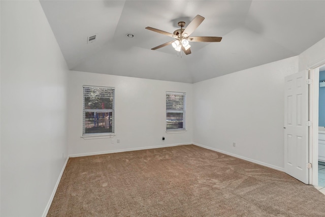 unfurnished room with carpet, a wealth of natural light, ceiling fan, and vaulted ceiling