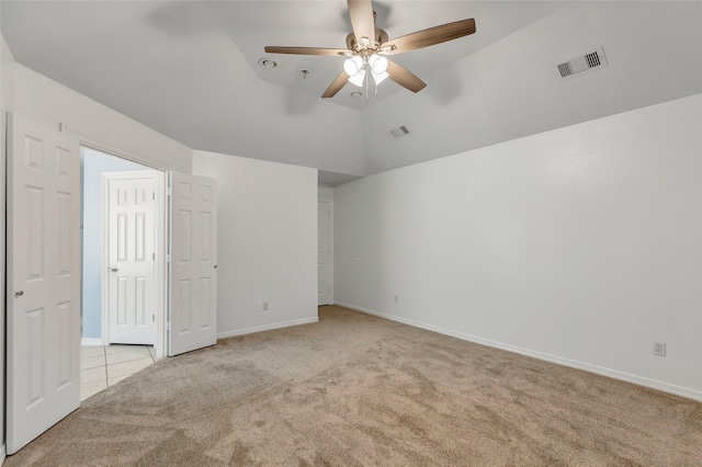 carpeted spare room featuring ceiling fan and vaulted ceiling