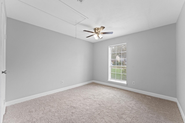 spare room featuring attic access, carpet floors, and baseboards