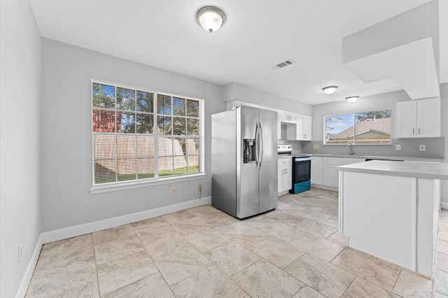 kitchen featuring white cabinetry, appliances with stainless steel finishes, light countertops, and baseboards