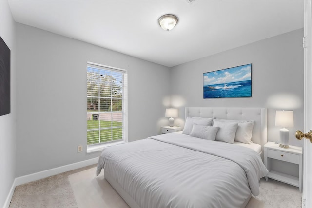 bedroom with light carpet and baseboards