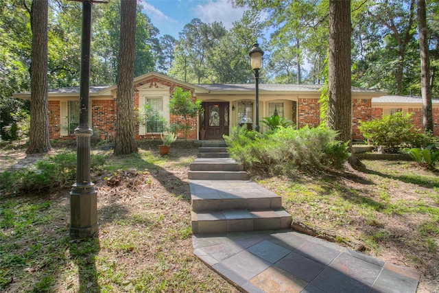 ranch-style house featuring brick siding