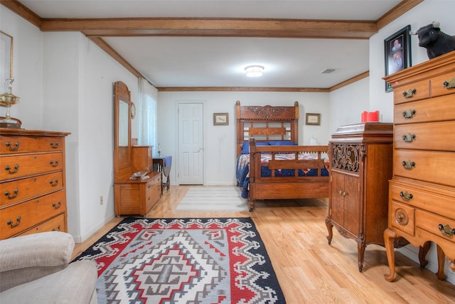 bedroom featuring light wood-style flooring, visible vents, ornamental molding, and baseboards