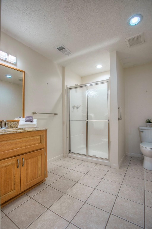 bathroom with tile patterned flooring, vanity, a textured ceiling, and walk in shower