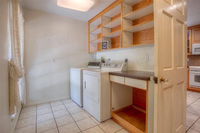 clothes washing area featuring laundry area, baseboards, light tile patterned flooring, and independent washer and dryer