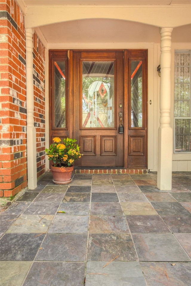 doorway to property featuring brick siding