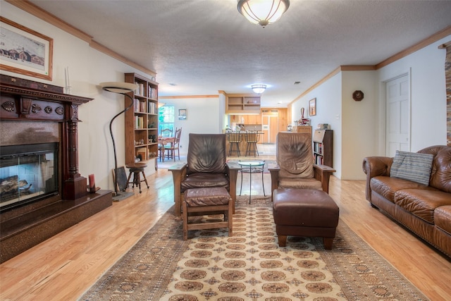 living room with crown molding, a textured ceiling, and wood finished floors