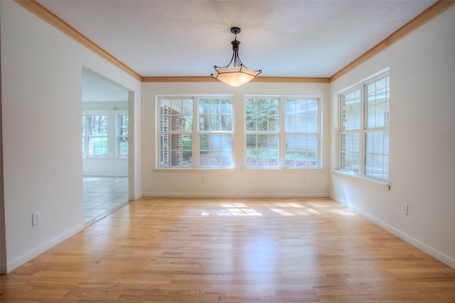 unfurnished dining area featuring ornamental molding, a wealth of natural light, and light hardwood / wood-style flooring