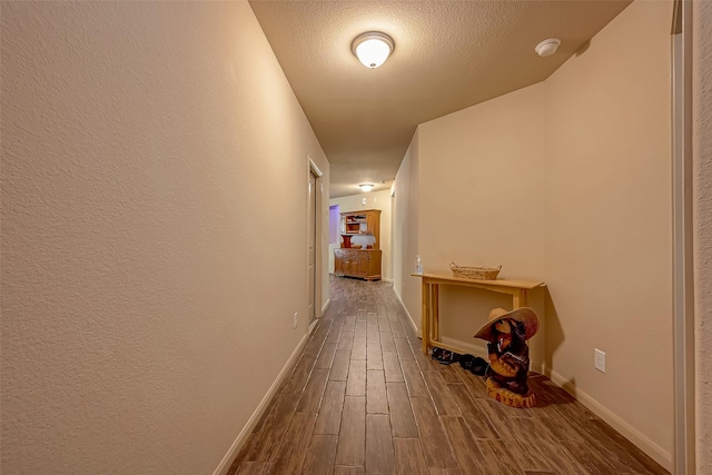 corridor featuring wood-type flooring and a textured ceiling