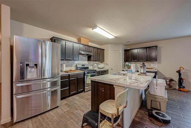 kitchen with appliances with stainless steel finishes, dark brown cabinetry, and wood-type flooring