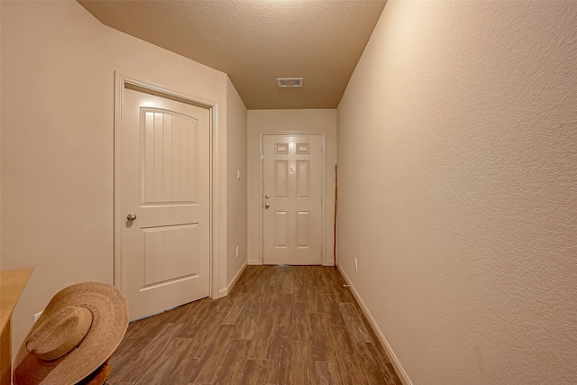 hall featuring hardwood / wood-style floors and a textured ceiling