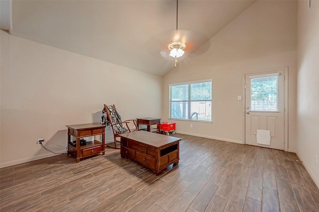 living area with ceiling fan, lofted ceiling, and light wood-type flooring