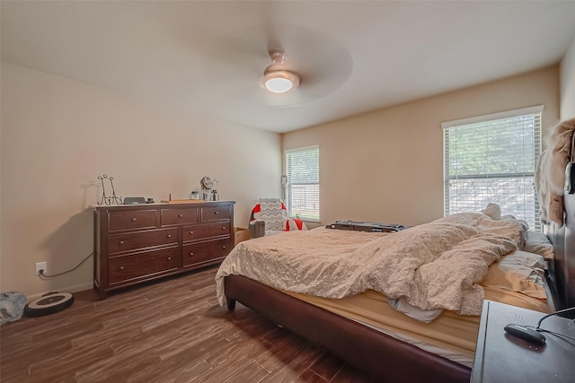 bedroom with dark hardwood / wood-style floors, ceiling fan, and multiple windows