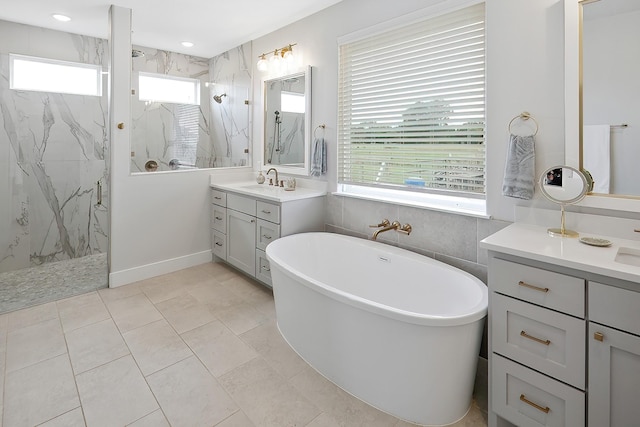 bathroom with tile patterned floors, vanity, a healthy amount of sunlight, and separate shower and tub