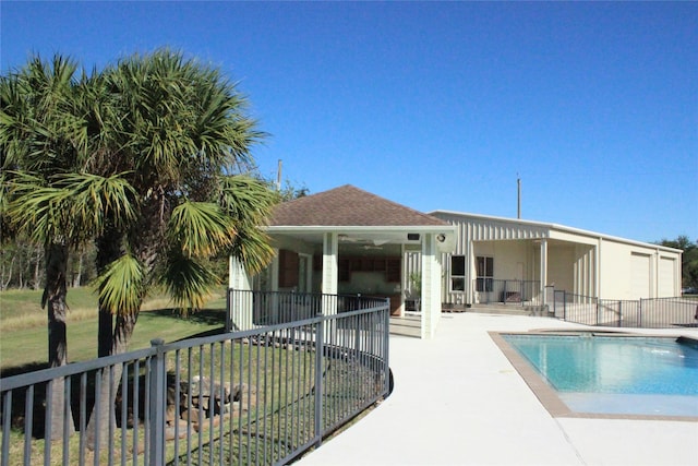 back of property featuring a fenced in pool, a patio area, and a lawn