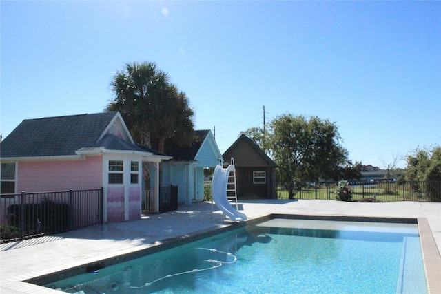 view of swimming pool with an outdoor structure and a water slide