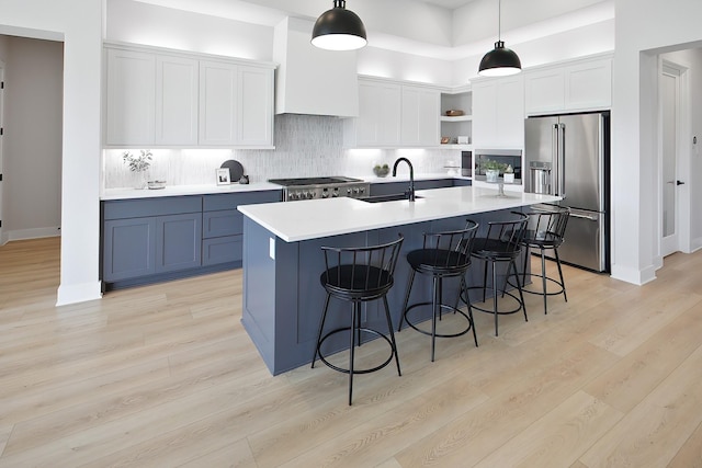 kitchen with appliances with stainless steel finishes, backsplash, decorative light fixtures, and white cabinetry