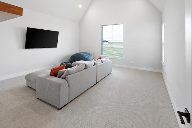 carpeted living room with high vaulted ceiling