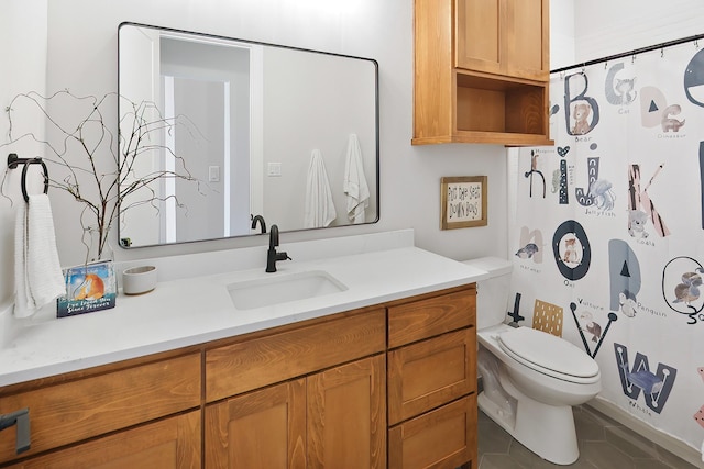 bathroom with tile patterned flooring, vanity, and toilet